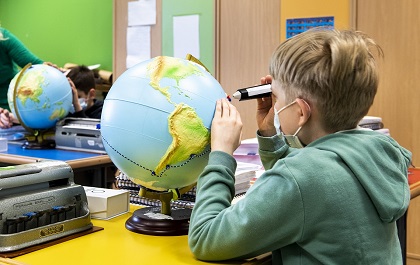 Alumno con globo del mundo accesible
