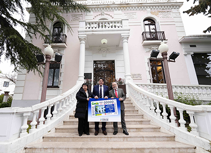 Teresa Rodríguez, David Pérez y Luis Natalio Royo, ante el edificio e la Junta Municipal de Hortaleza que es la imagen del cupón