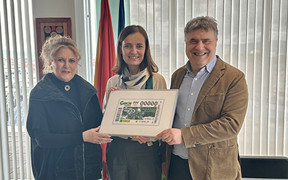 Pilar Herrero, Ana Bretaña y Valetín Fortún sostienen una lámina enmarcada con este cupón